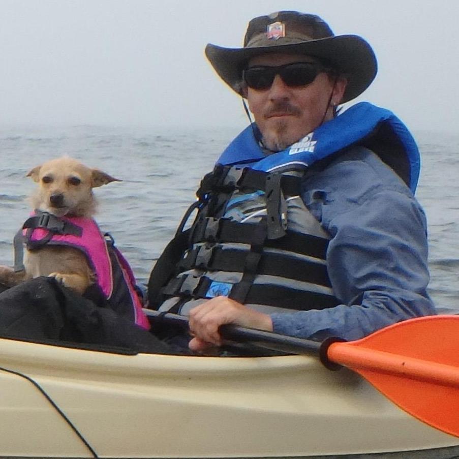 This is what Mike looks like when he is in is in a small boat with a small dog.